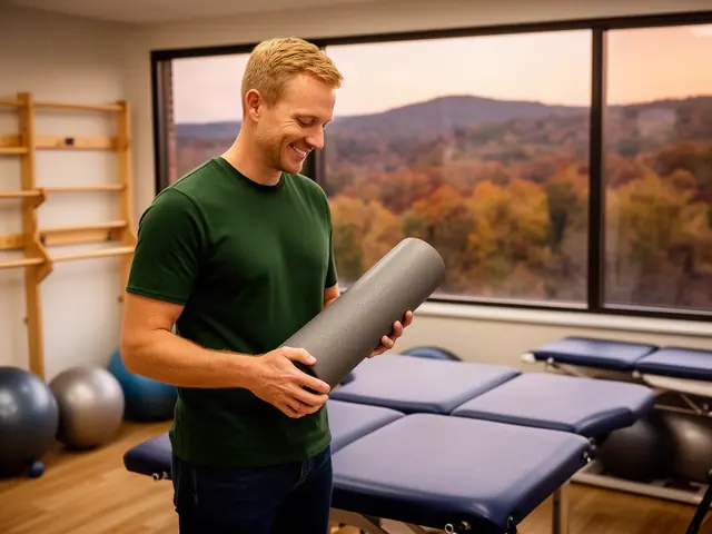 A therapist standing between padded treatment tables in a bright clinic.